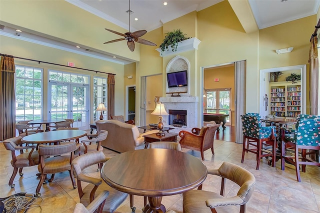 tiled dining area with ceiling fan, a towering ceiling, and ornamental molding