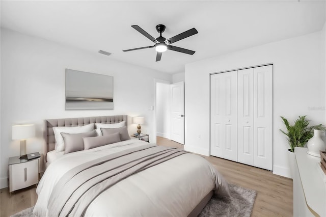 bedroom featuring ceiling fan, light hardwood / wood-style flooring, and a closet