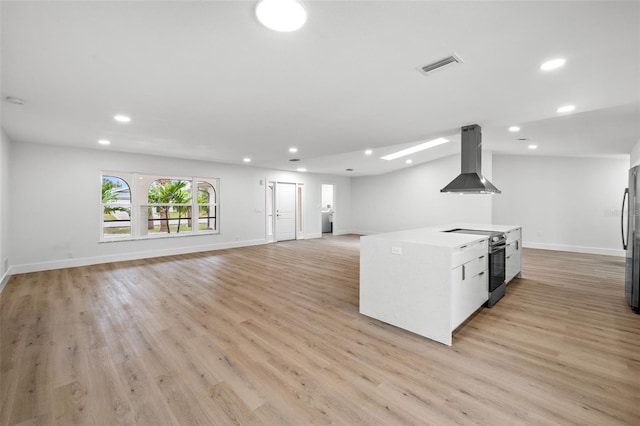 kitchen featuring appliances with stainless steel finishes, white cabinetry, light wood-type flooring, and island exhaust hood