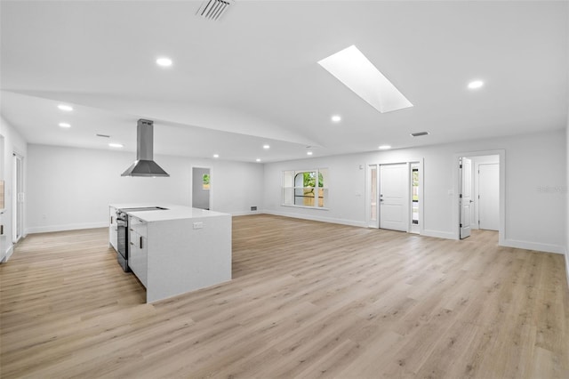 living room with lofted ceiling with skylight and light hardwood / wood-style floors