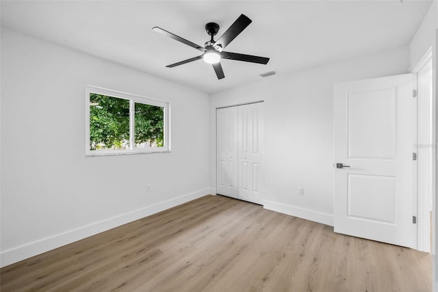 unfurnished bedroom with light hardwood / wood-style floors, a closet, and ceiling fan