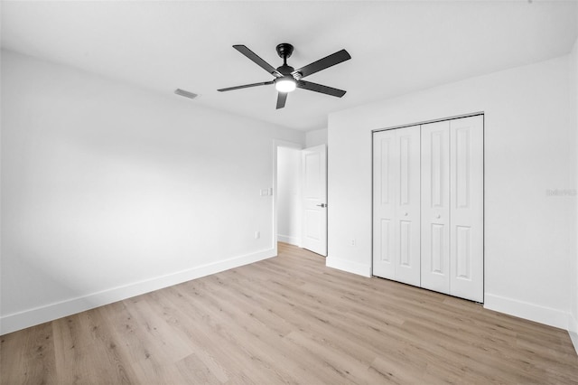 unfurnished bedroom with light hardwood / wood-style floors, a closet, and ceiling fan