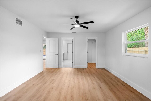 empty room with ceiling fan and light hardwood / wood-style floors