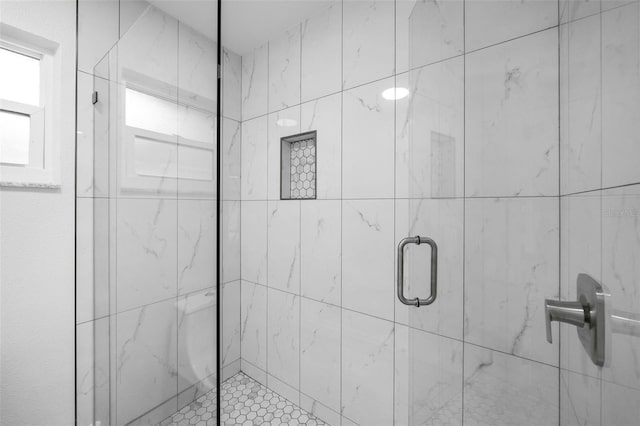 bathroom featuring a shower with door