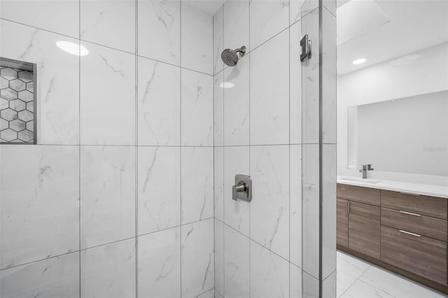 bathroom with vanity and a tile shower