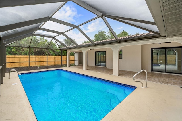 view of pool with a patio area and glass enclosure