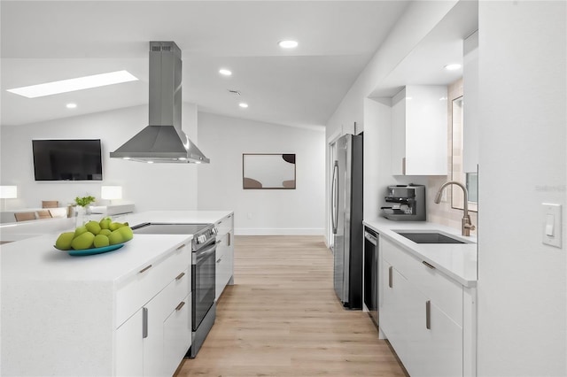 kitchen with white cabinets, island exhaust hood, sink, light hardwood / wood-style floors, and vaulted ceiling with skylight