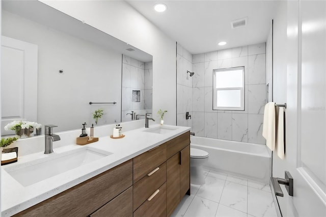 full bathroom featuring toilet, tile patterned floors, tiled shower / bath, and double sink vanity