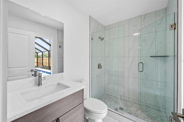 bathroom with a shower with shower door, vanity, and toilet