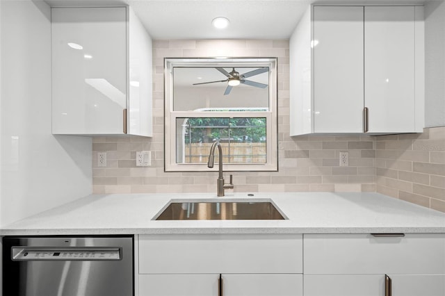 kitchen featuring tasteful backsplash, white cabinets, dishwasher, ceiling fan, and sink