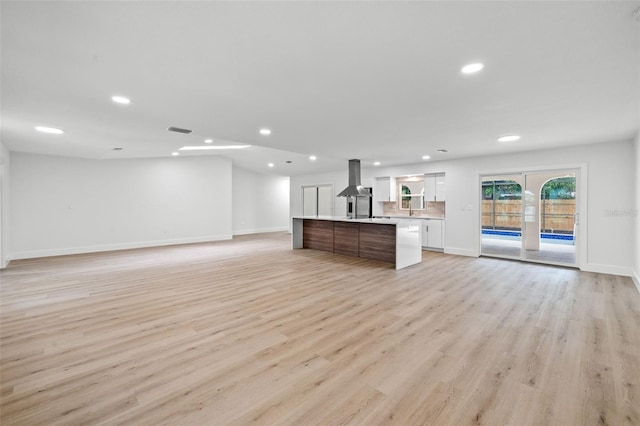 unfurnished living room with light hardwood / wood-style flooring and sink