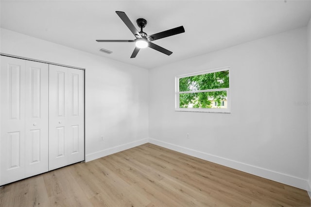 unfurnished bedroom featuring light hardwood / wood-style flooring, a closet, and ceiling fan