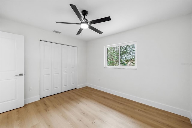 unfurnished bedroom featuring light hardwood / wood-style floors, a closet, and ceiling fan