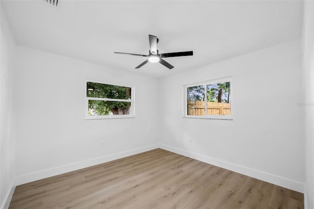 empty room with ceiling fan and light hardwood / wood-style floors