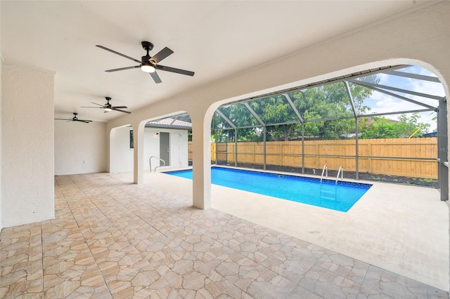 view of pool featuring a patio, ceiling fan, and glass enclosure