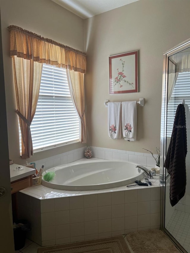 bathroom with vanity and tiled bath