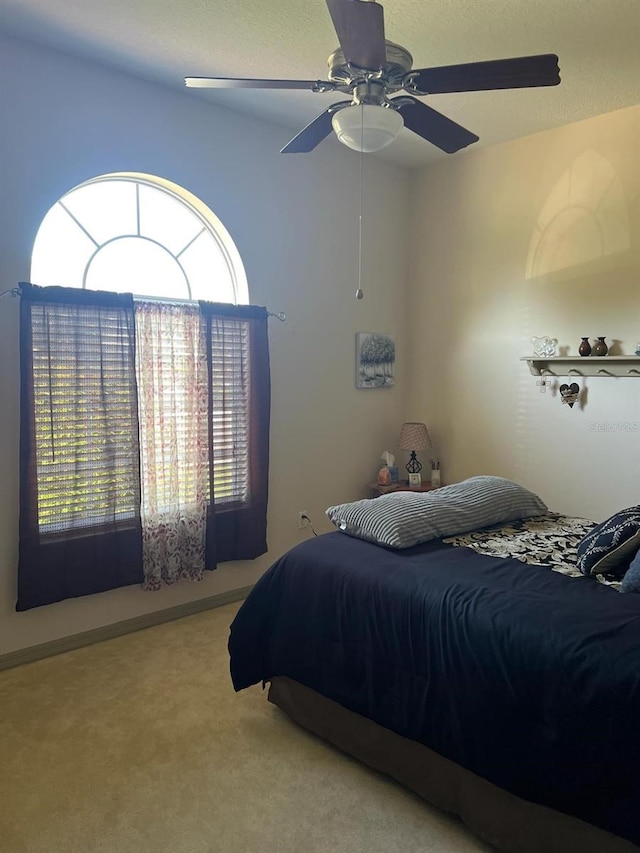 bedroom with ceiling fan and light carpet