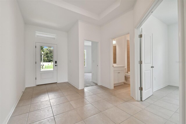 tiled entrance foyer featuring a raised ceiling