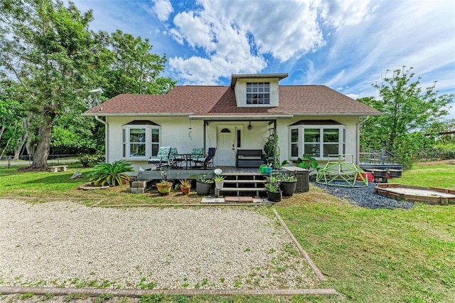 view of front facade with a wooden deck and a front yard