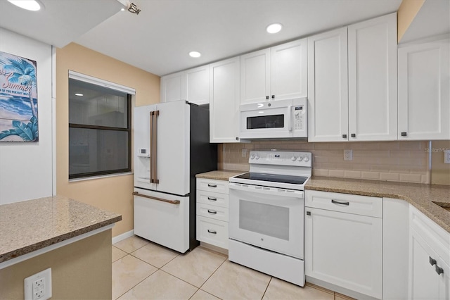 kitchen with light stone counters, white cabinets, white appliances, light tile flooring, and backsplash