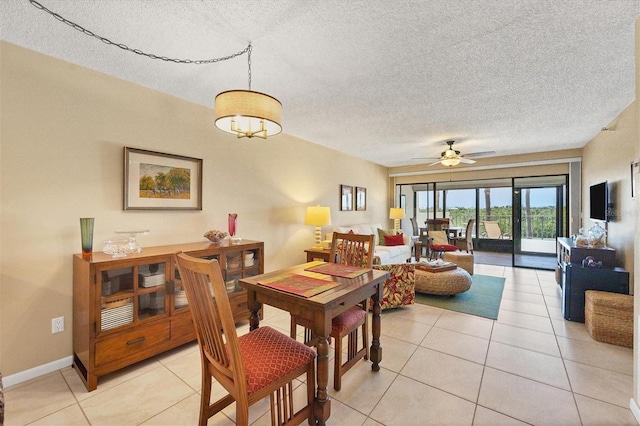 dining room with ceiling fan, light tile floors, and a textured ceiling