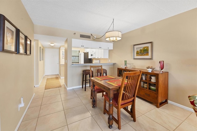 tiled dining area featuring a textured ceiling