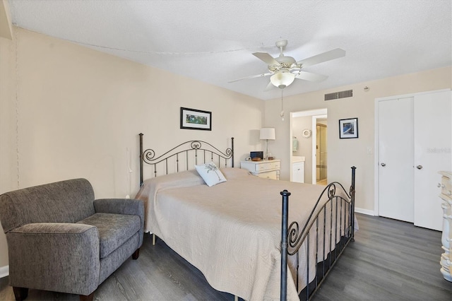 bedroom featuring dark hardwood / wood-style flooring, ceiling fan, a textured ceiling, and ensuite bathroom