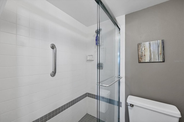 bathroom with toilet and a shower with shower door