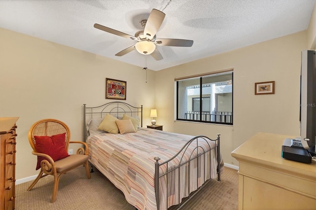 bedroom with ceiling fan, dark carpet, and a textured ceiling