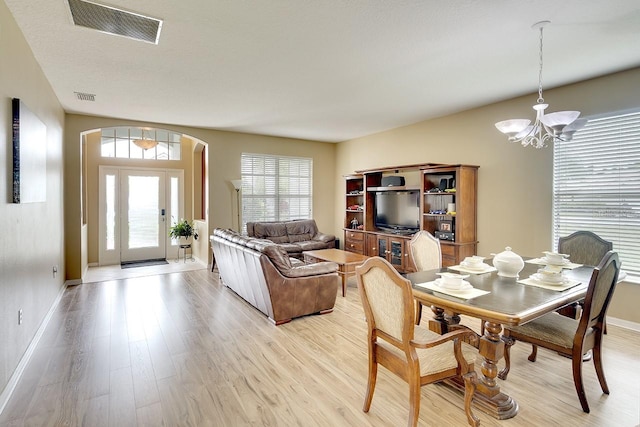 dining space featuring light hardwood / wood-style flooring and a chandelier