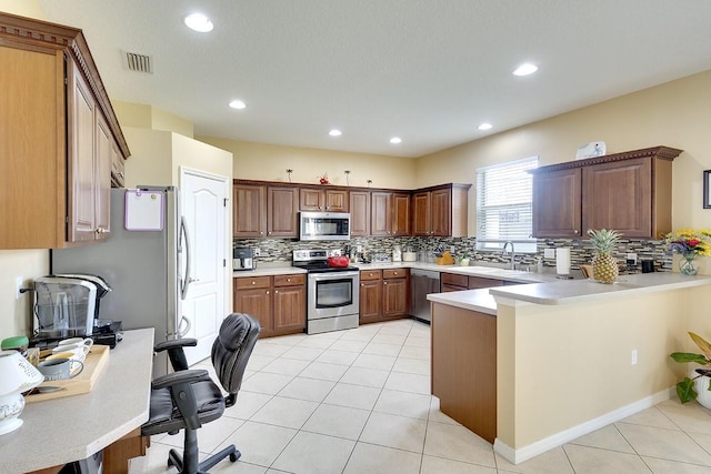 kitchen with appliances with stainless steel finishes, sink, light tile flooring, backsplash, and kitchen peninsula