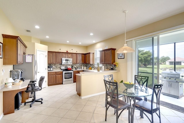 kitchen featuring kitchen peninsula, backsplash, stainless steel appliances, light tile flooring, and pendant lighting