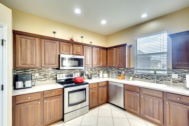 kitchen with backsplash, stainless steel appliances, and light tile floors