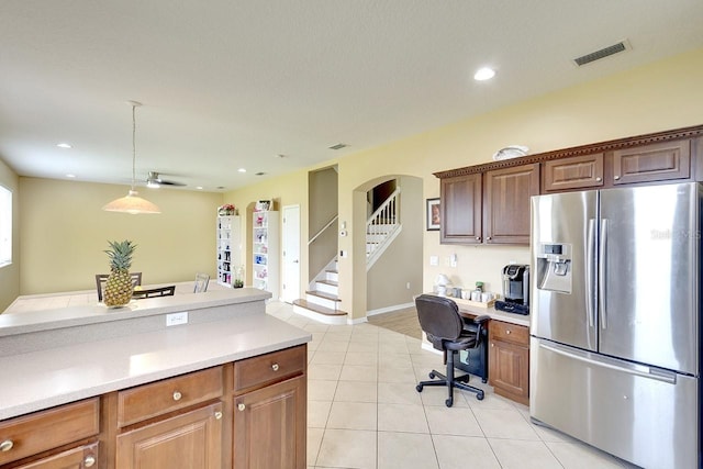 kitchen with pendant lighting, stainless steel refrigerator with ice dispenser, and light tile flooring