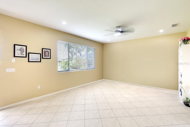 unfurnished room with a textured ceiling, ceiling fan, and light tile floors