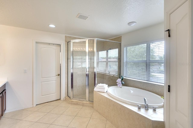 bathroom featuring tile flooring, a textured ceiling, vanity, and plus walk in shower