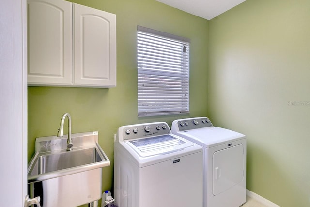 laundry room featuring cabinets, sink, and separate washer and dryer