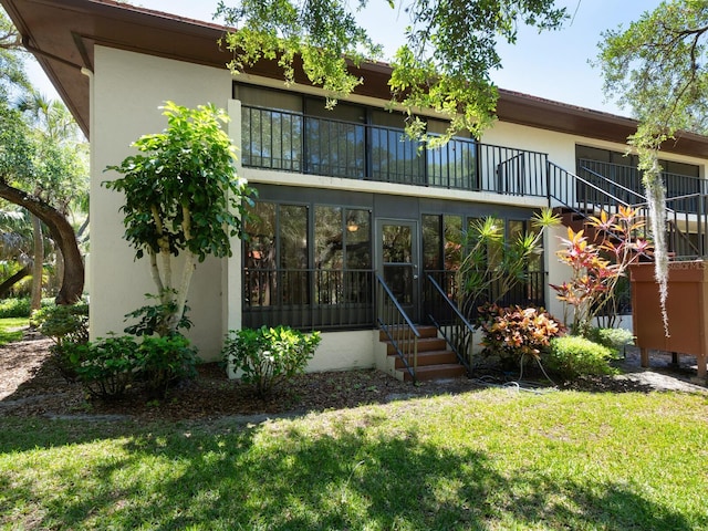 view of front facade featuring a balcony and a front yard