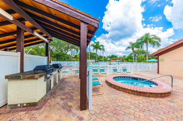 view of terrace featuring a pool with hot tub and area for grilling