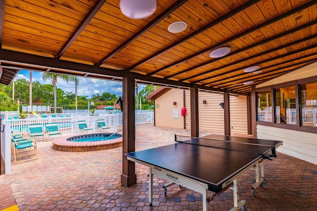 view of terrace featuring a swimming pool with hot tub