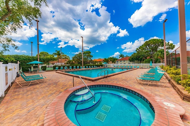 view of swimming pool with a community hot tub and a patio area