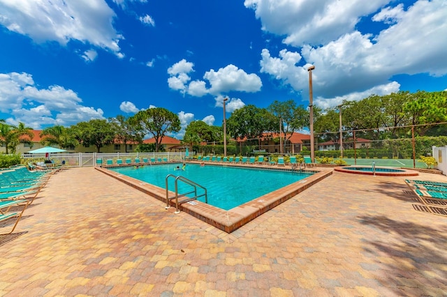 view of pool with a hot tub and a patio