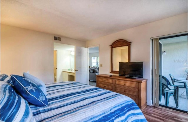 bedroom featuring dark hardwood / wood-style floors and connected bathroom