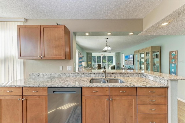 kitchen with sink, light wood-type flooring, dishwasher, and a textured ceiling