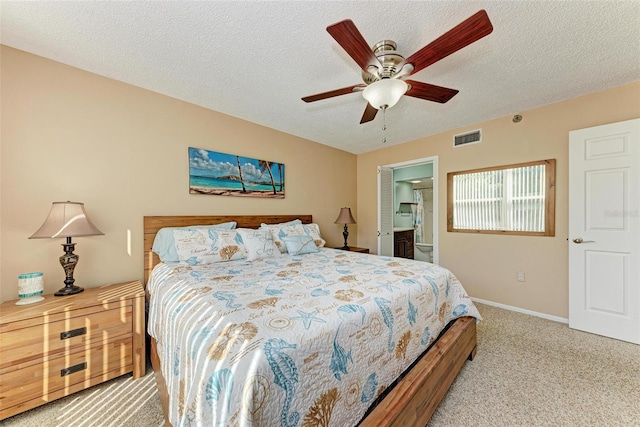 bedroom with a textured ceiling, ceiling fan, light carpet, and ensuite bathroom