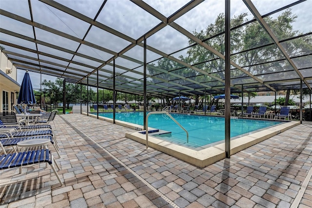 view of swimming pool with a patio and a lanai