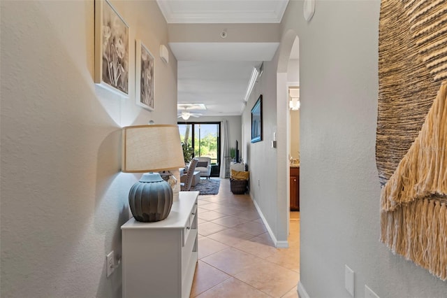 corridor with ornamental molding and light tile floors