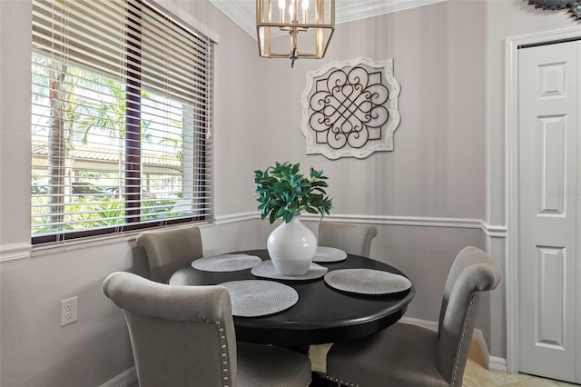 dining space with crown molding and a chandelier