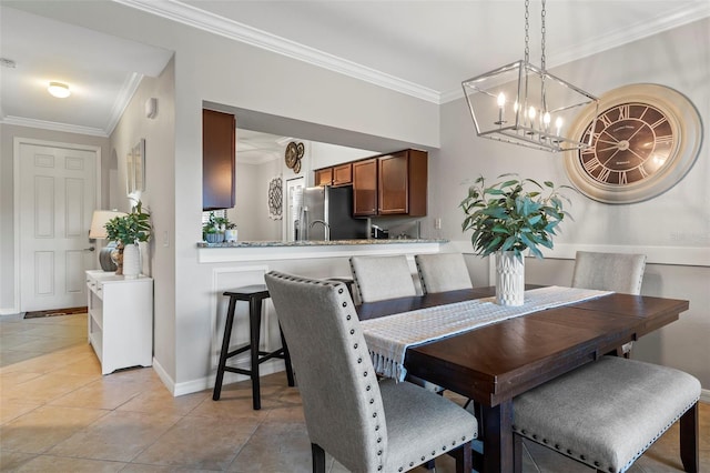 dining space featuring a notable chandelier, crown molding, and light tile floors