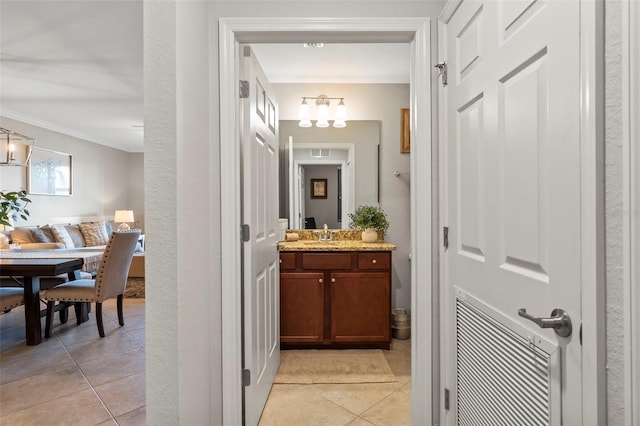 bathroom featuring crown molding, tile floors, and vanity